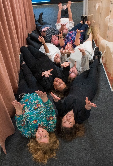 personer på ett golv med uppsträckta ärmar