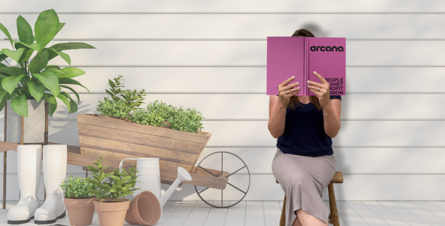 Tjej som sitter på en pall och läser en bok i uterummet